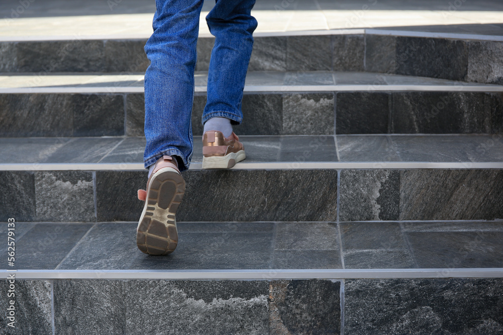 Woman walking up stylish stone stairs outdoors, closeup