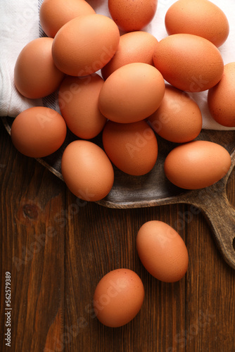 Raw brown chicken eggs on wooden table, flat lay