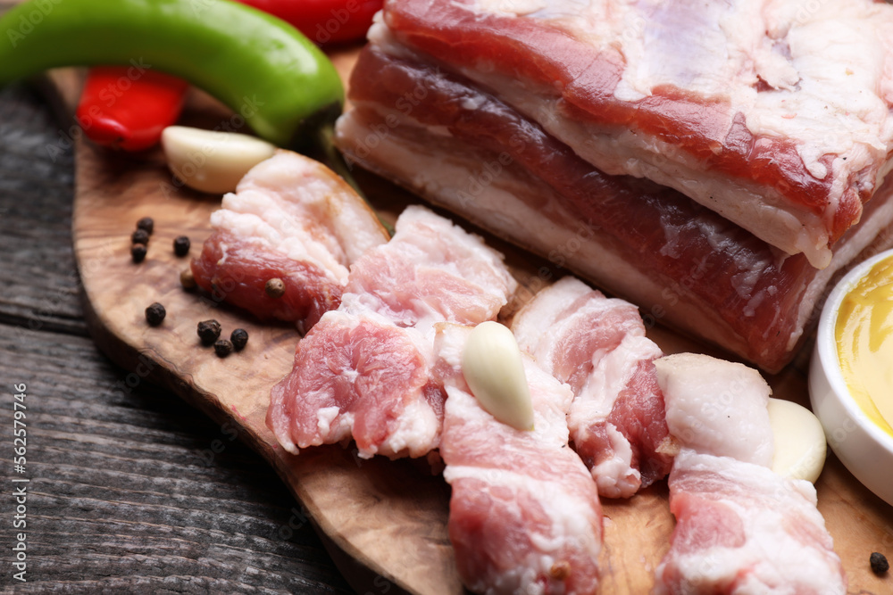 Pieces of pork fatback on wooden table, closeup