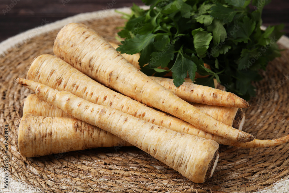 Raw parsley roots and fresh herb on wicker mat, closeup Raw parsley roots and fresh herb on wicker mat, closeup