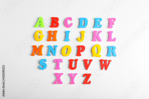 Colorful magnetic letters on white background  flat lay. Alphabetical order