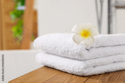 Stacked towels on tub tray in bathroom, closeup. Space for text
