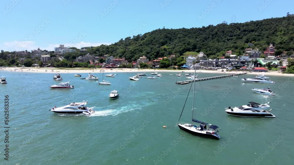 Low flight drone aerial scene flying over speedboats yachts and luxury boats with pier in paradisiaca beach in Canajurê beach florianopolis santa catarina tropical Low flight drone aerial scene flying over speedboats yachts and luxury boats with pier in paradisiaca beach in Canajurê beach florianopolis santa catarina tropical