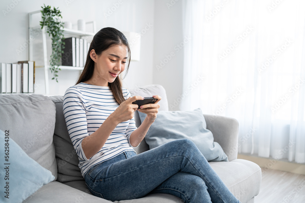 Asian young beautiful woman playing mobile game on smartphone at home. Asian young beautiful woman playing mobile game on smartphone at home.