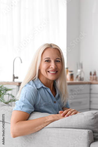 Mature woman sitting on sofa in kitchen