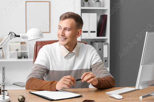 Young businessman with pen ...