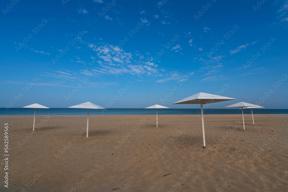 A deserted beach with wooden umbrellas on the shore of the Baltic Sea in the village of Yantarny, Kaliningrad region, Russia