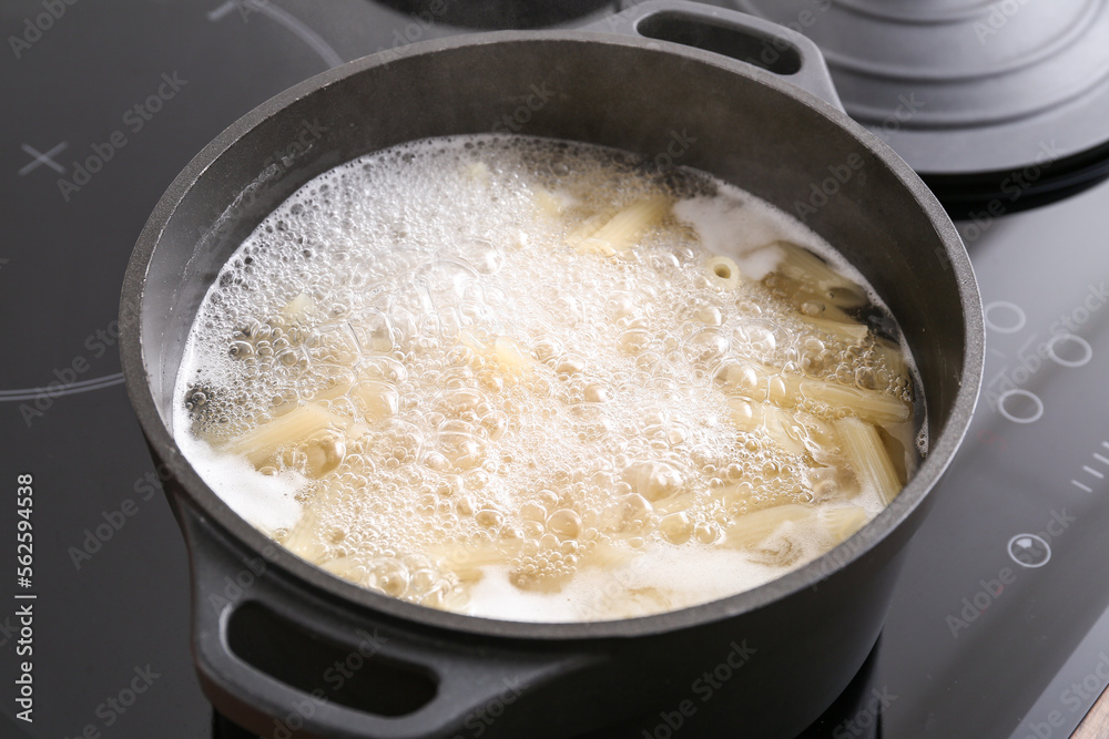 Cooking pot with boiling pasta on electric stove, closeup Cooking pot with boiling pasta on electric stove, closeup