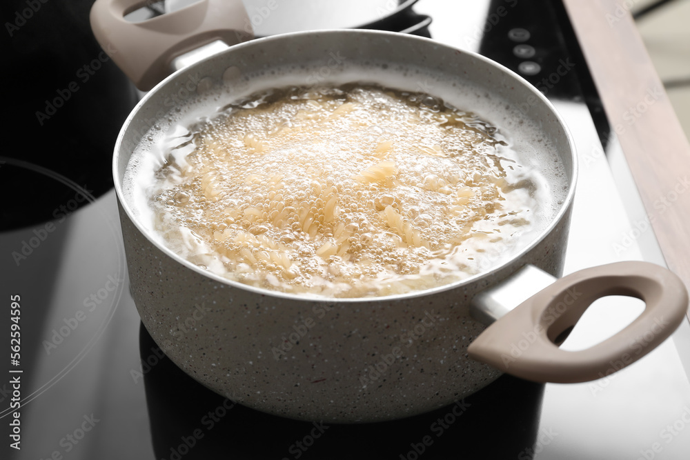 Cooking pot with boiling pasta on stove, closeup Cooking pot with boiling pasta on stove, closeup