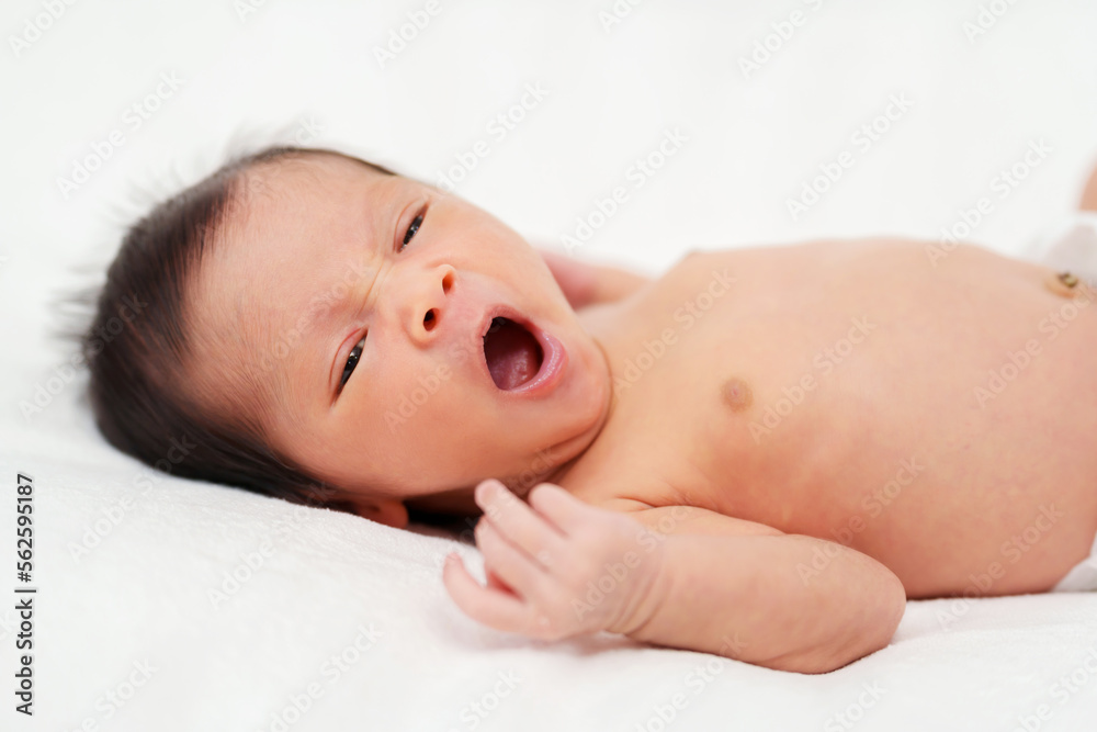 newborn baby yawning on bed newborn baby yawning on bed