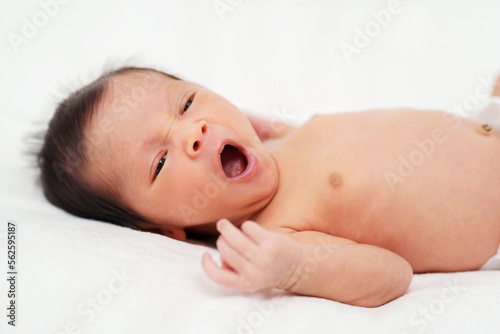 newborn baby yawning on bed