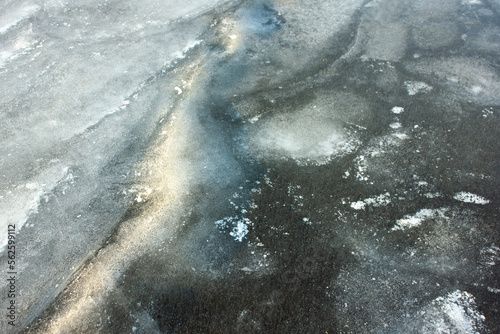 Cacks in thick solid layer of ice of a frozen lake