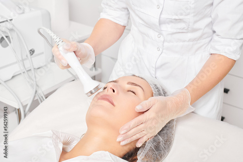 Cosmetologist makes ultrasound skin tightening for rejuvenation woman face using phonophoresis