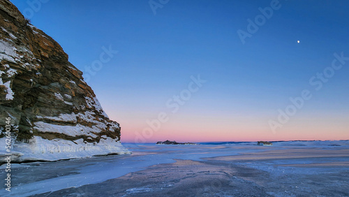 Winter sea sunset. Panoramic view of the snow-covered shore of the frozen sea  the lake at sunset. Shards of ice close-up. Christmas  seasons  winter.  Selective focus.