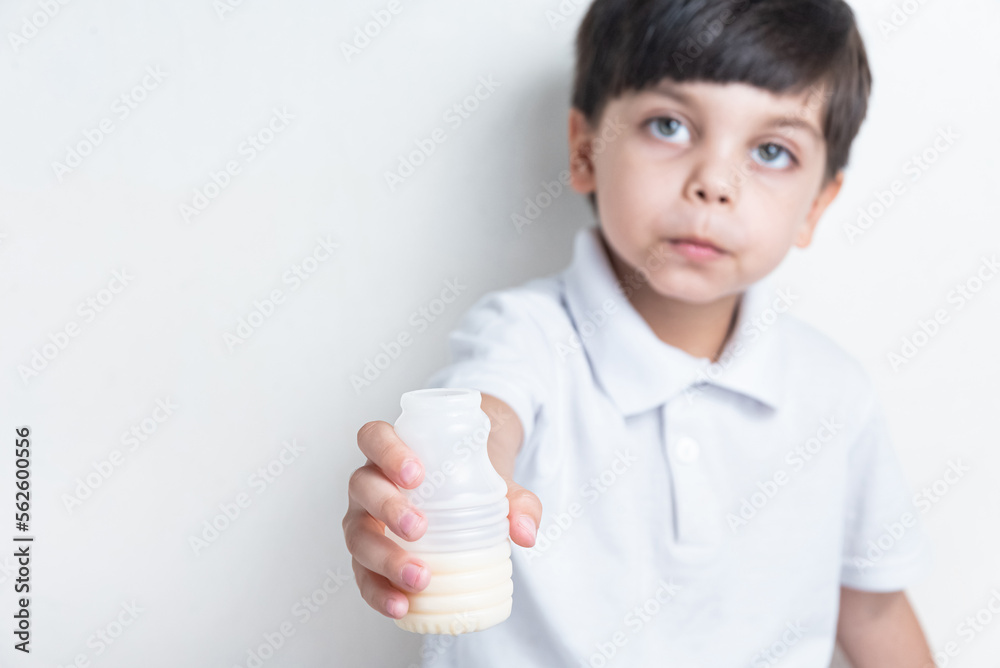 Cute boy in white shirt on white background - drinking fermented milk Cute boy in white shirt on white background - drinking fermented milk
