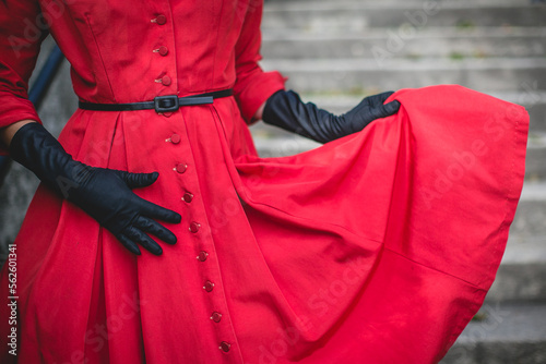 woman in red vintage dress and long black gloves
