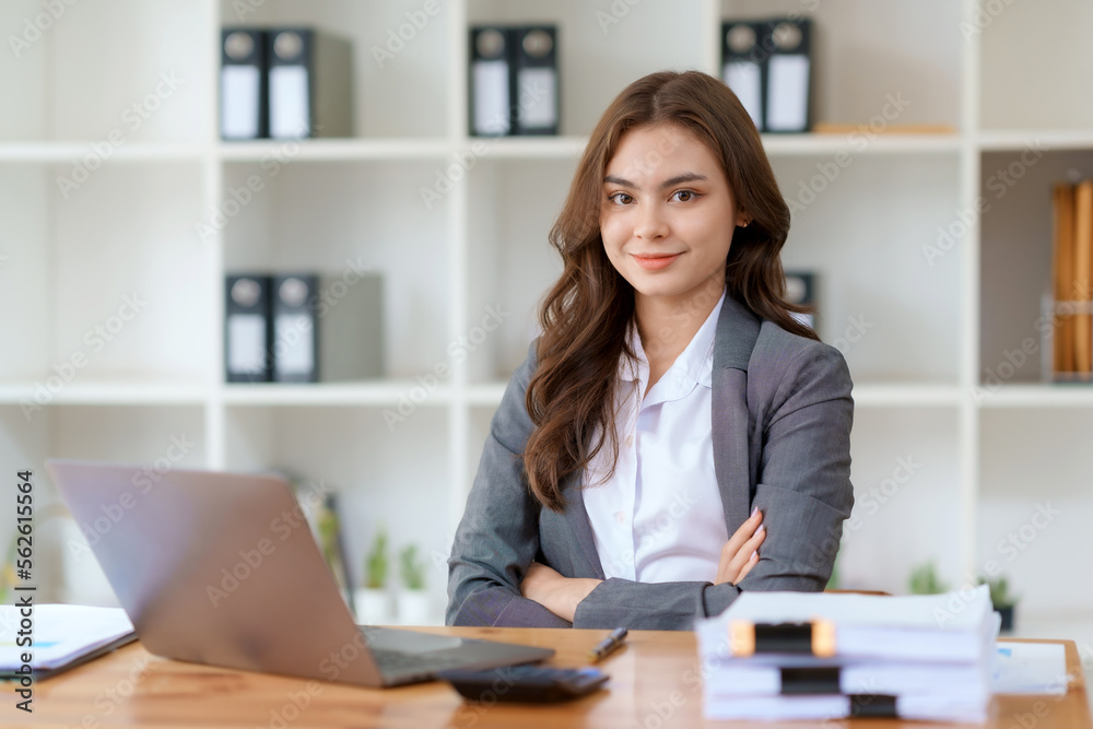 Beautiful and confident Asian businesswoman with arms crossed at office thinking of new ideas at work.