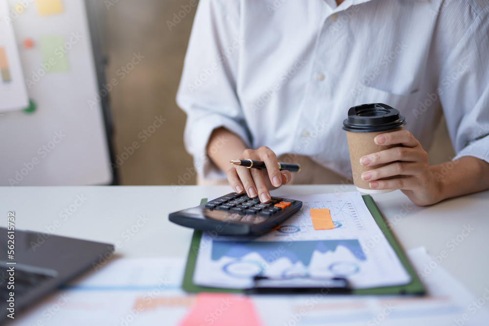 Close-up businesswoman using calculator to check job detail. Close-up businesswoman using calculator to check job detail.