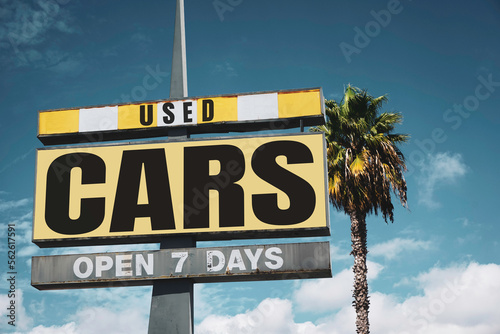 Aged and worn vintage used cars sign with palm tree #562617591