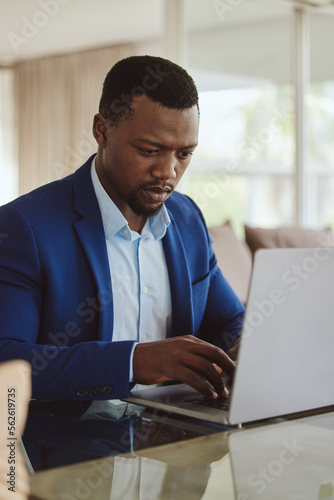 Laptop research, investment and focus of black man planning wealth, entrepreneur profit and stock market. Corporate, business and rich manager, boss or professional person typing on pc for trading