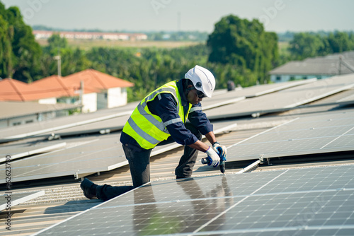 Wallpaper Mural Well-equipped worker in protective clothing working and examining solar panels on a photovoltaic rooftop plant. Concept of maintenance and installation of solar station. Torontodigital.ca