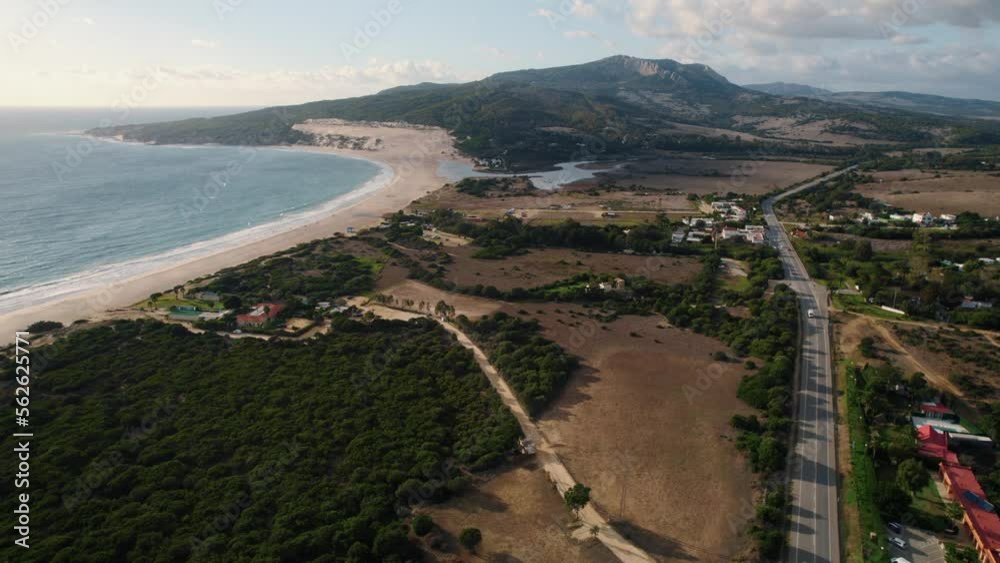 Wide aerial view of the ocean, rural farmland, and main highway in Tarifa, Spain.