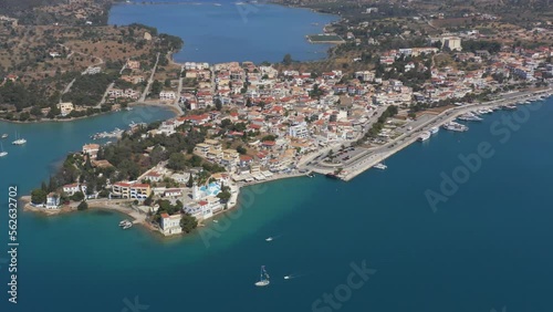 An aerial drone view of Port Cheli in Greece, during summer, with a vibrant blue sea and several sailboats passing photo