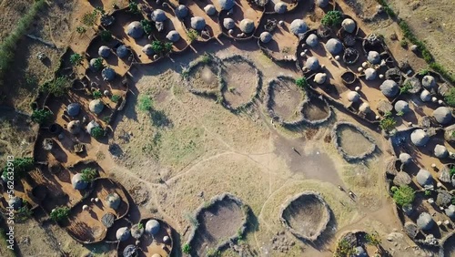 Aerial drone zoom out view from the center of a village in the Karamoja region, also called Manyatta or Ere, in Uganda, during a sunny day. photo