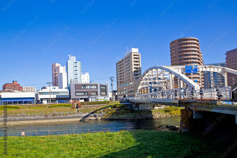 Mount Iwate scene with buildings and promenade at Katakami river in  Morioka city, Iwate prefecture, Tohoku, Japan.