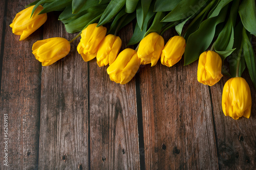 beautiful bouquet of yellow tulips on wooden background.