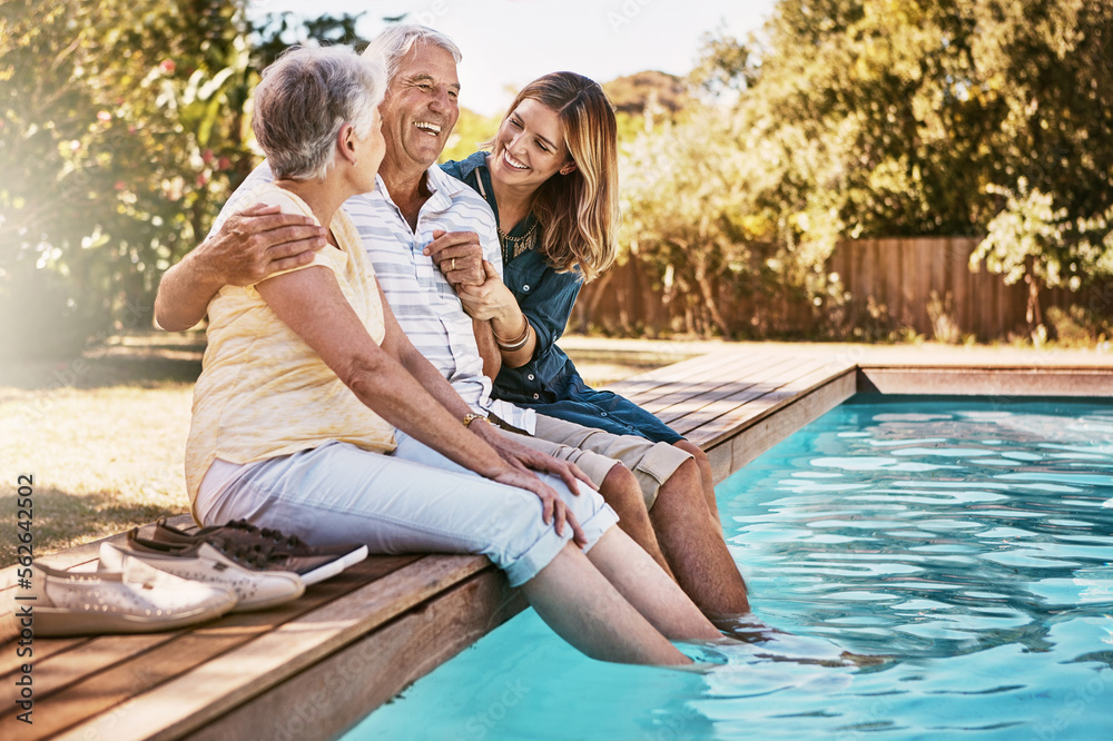 Fototapeta premium Relax, senior couple and woman with feet in swimming pool enjoying summer holiday, vacation and weekend. Family, love and daughter with elderly parents for bonding, quality time and laughing together