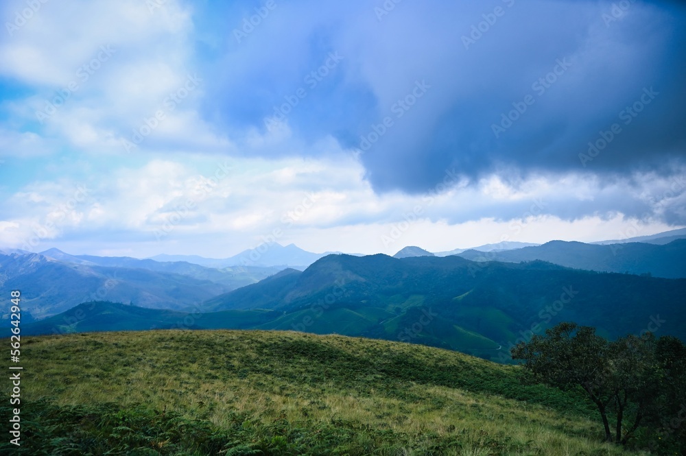 HDR landscape of Eravikulam National Park showing greenery and clouds near hills of western ghat