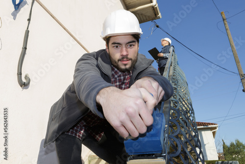man sanding exterior hand rail photo