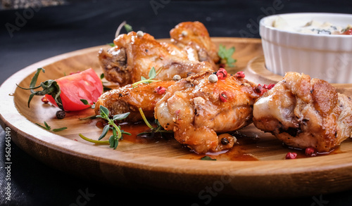 grilled chicken wings and sauce on a wooden tray