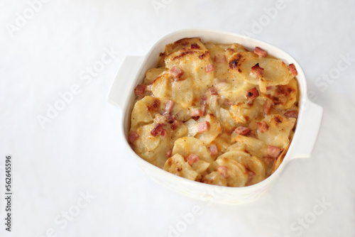 Gluten Free Cheesy Scalloped Potatoes and Ham Dish in White Ceramic Baking Dish with a White Background