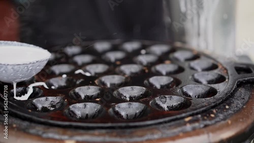 coconut rice pancake, kind of Thai sweetmeat, made from glutinous rice flour, sugar and coconut milk, poured in a container that look like small holes and set on the fire stove