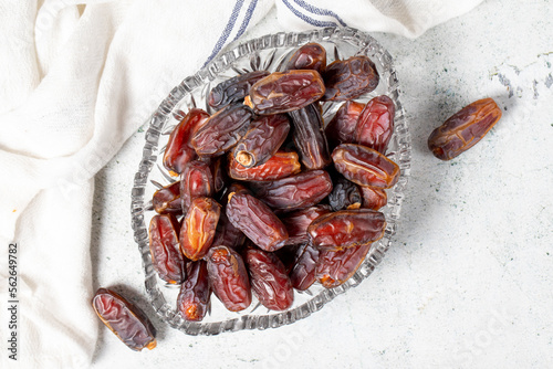 Date fruit on stone background. Organic Medjoul dates in a glass bowl. Ramadan food. Top view photo