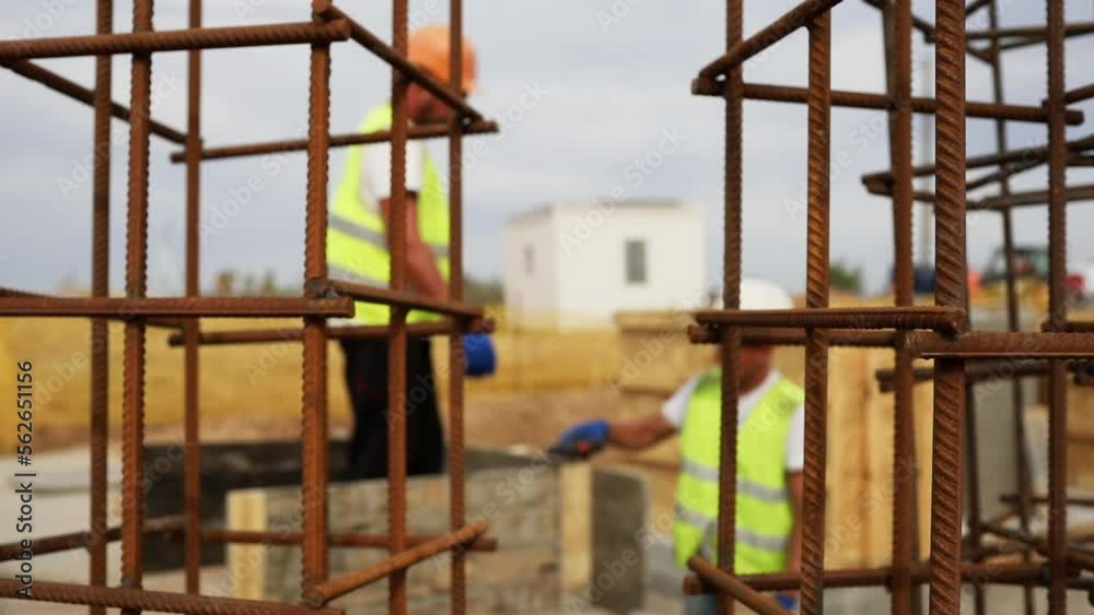 Metal frame of reinforced concrete structures, builders are working in the background. Metal frame of reinforced concrete structures, builders are working in the background.