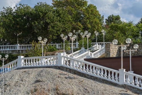 Gelendzhik bay. Embankment of resort town. Large staircase with stone balusters with lanterns from embankment to city beach. Selective focus. Atmosphere of serene rest and relaxation.