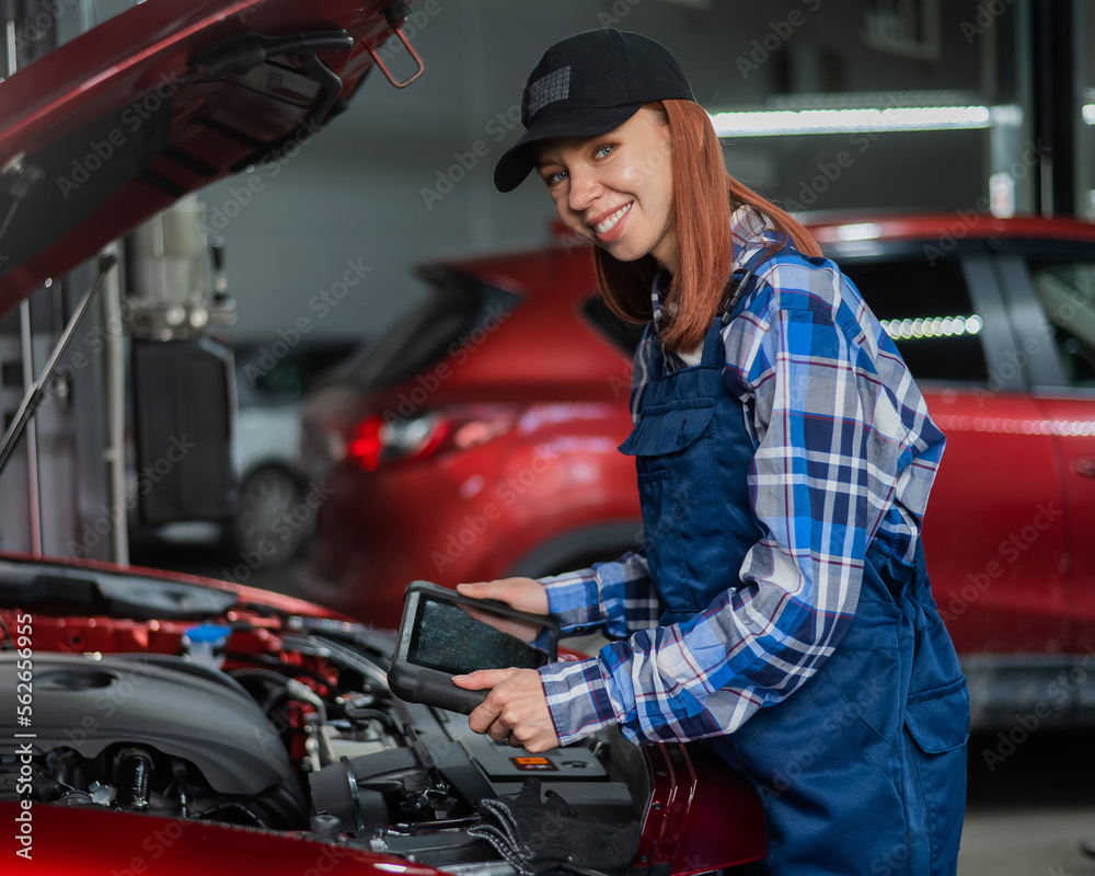 Caucasian female auto mechanic uses a special computer to diagnose faults. Caucasian female auto mechanic uses a special computer to diagnose faults.