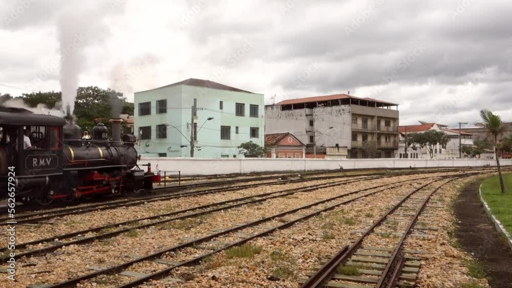 ancient steam train departuring from station in the city, releasing smoke in the air ancient steam train departuring from station in the city, releasing smoke in the air