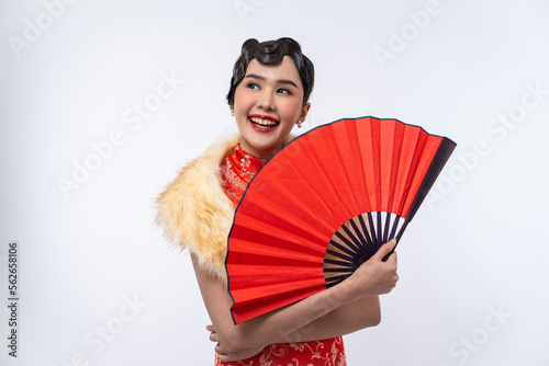 Beautiful Asian woman wearing cheongsam with fur cape holding red fan isolated on white background, Happy Chinese New Year.