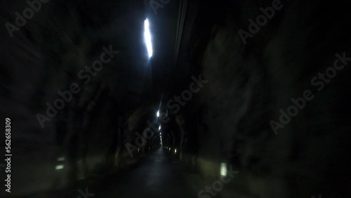 Fast car ride through a dark tunnel. The tunnel is narrow and leads to Binn, a village in the Swiss Alps photo