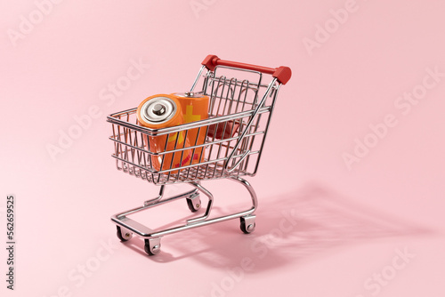 Shoping cart with two batteries inside, energy price concept on pink background