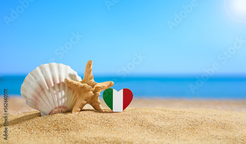 Beautiful beach in Italy. Flag of Italy in the shape of a heart and shells on a sandy beach.