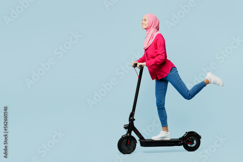 Photography Full body side view young fun arabian muslim woman wear pink abaya hijab riding