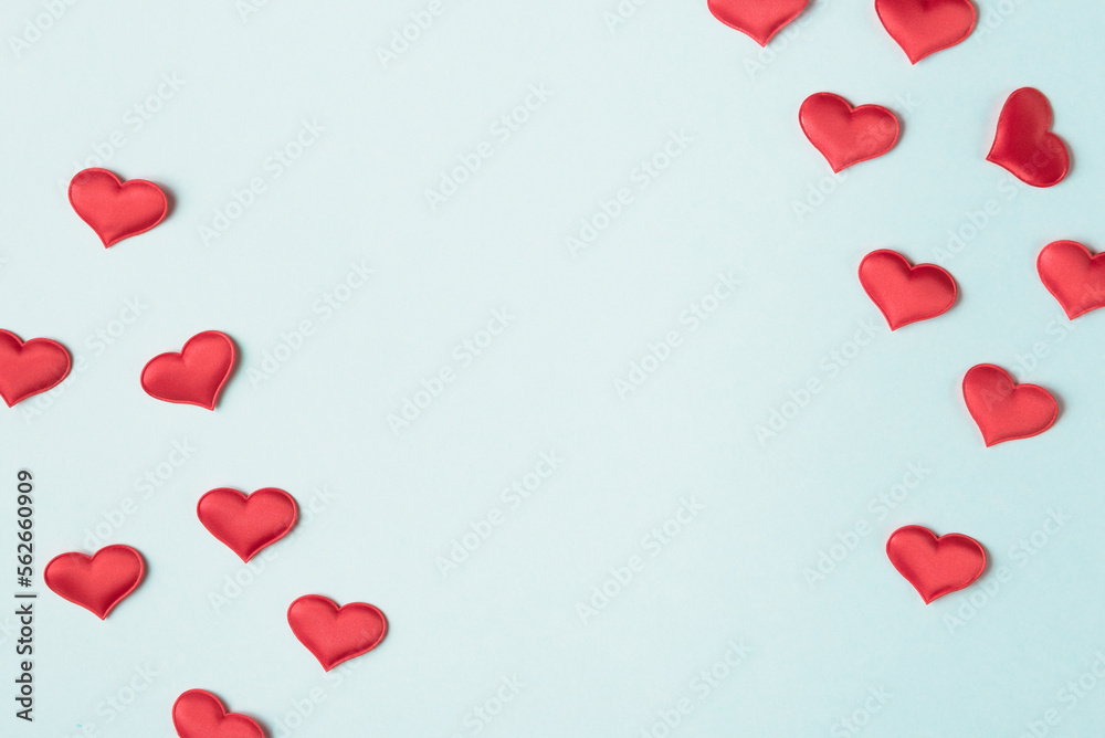 Valentine’s day background with red hearts on light blue background