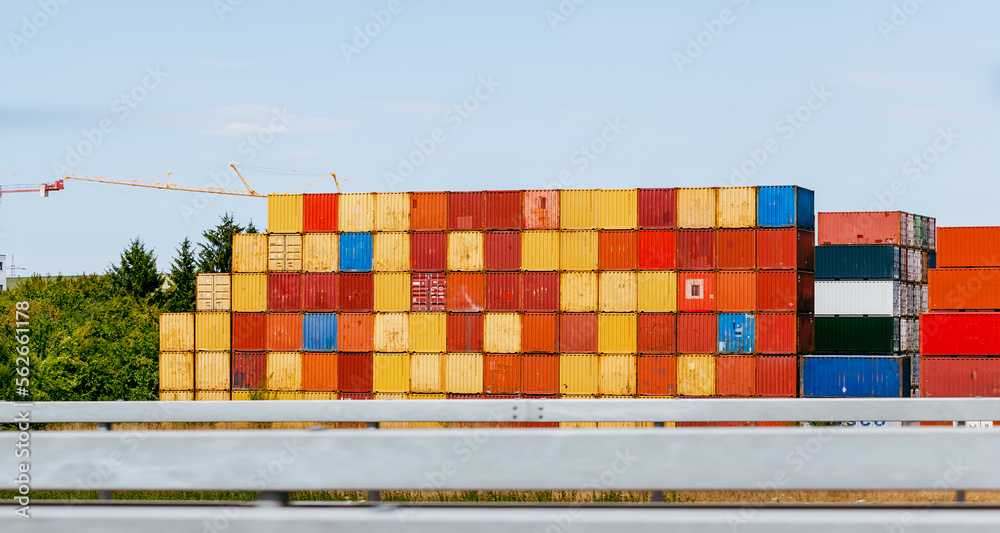 Cargo containers stacked at a terminal along the motorway