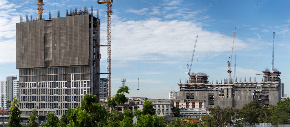 Crane and construction site working on building complex at sunset, developing city concept.