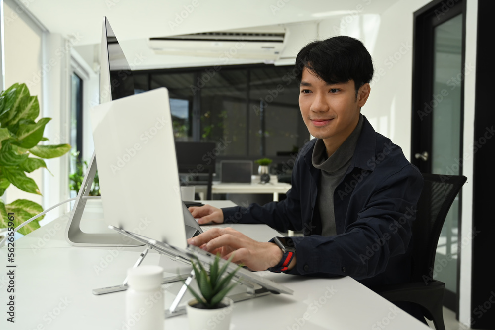 Handsome asian male graphic designer working on new project in contemporary office Handsome asian male graphic designer working on new project in contemporary office